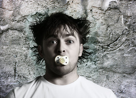 Man with  baby's dummy. Crazy male faceの写真素材