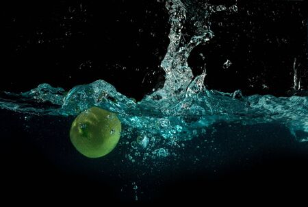 lime are dropped into blue waterの写真素材
