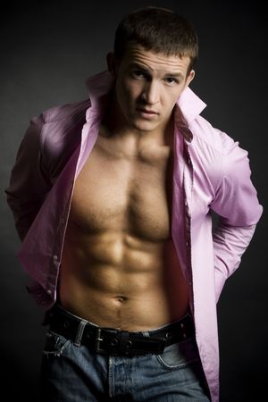 Beautiful young man posing on dark backgroundの写真素材