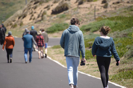 Men, women walking down a road, conceptual phot, hiking in the sun, in motion at a park