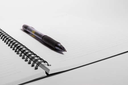 Black pen on white clear notepad against a white backgroundの写真素材