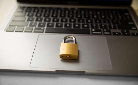 Golden metal padlock on laptop keyboard illustrating computer security conceptの写真素材