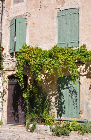 A cottage with green shutters in a Vaison-la-Romaine, in Provence, France.の写真素材