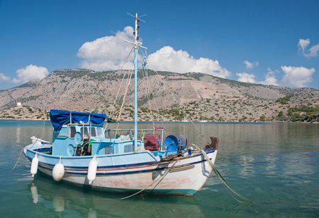 Greek fishing boat anchored at Panormitis Monastery on the Mediterranean Greek island of Symi, near...