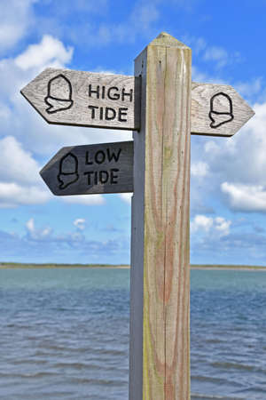 Coast path sign indication high and low tide footpath options, taken between Appledore and Northam in North Devon, England, on the southwest coast pathの写真素材