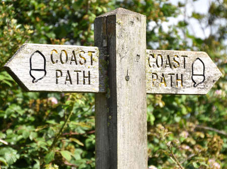Coast path sign indication high and low tide footpath options, taken between Appledore and Northam in North Devon, England, on the southwest coast pathの写真素材