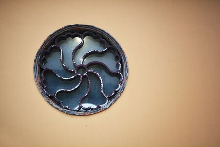 Round and vintage shape of glass window on a yellow wallの写真素材