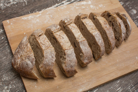 wheat flour with a fresh bread cutted into slices on the table