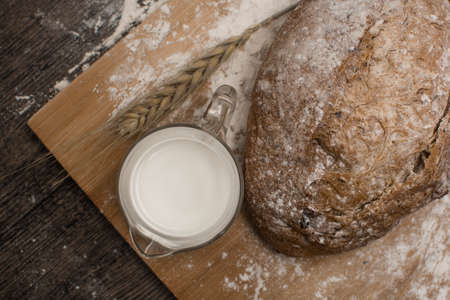 wheat flour with a fresh  hot bread and milk on the tableの写真素材