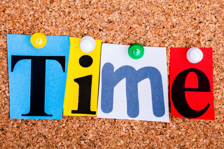 The word Time in cut out magazine letters pinned to a cork notice boardの写真素材