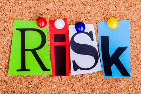 The word Risk in cut out magazine letters pinned to a cork notice board の写真素材
