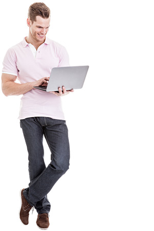 Casual young man working on laptop isolatedの写真素材