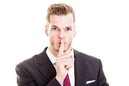Top secret! - Young businessman with finger on his lipsの写真素材