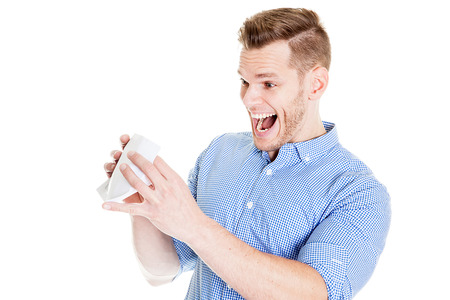 Young man shocked after opening an envelope, white bacgroundの写真素材