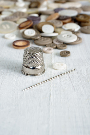 Sewing thimble needle and antique buttons  Selective focus on thimbleの写真素材