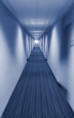 Long corridor vanishing point with applied motion blur filter in cold blue tintの写真素材
