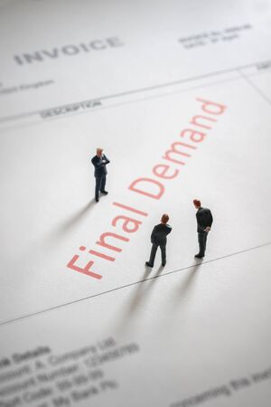 Business men gloomily pondering an overdue final demand invoice a finance or debt conceptの写真素材