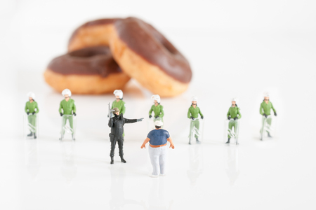 Police preventing an fat man from reaching donuts a public health obesity conceptの写真素材