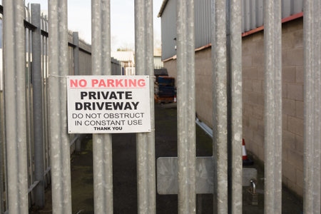 Set of locked security gates with a no parking sign at