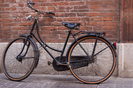 An old bike beside the wall の写真素材