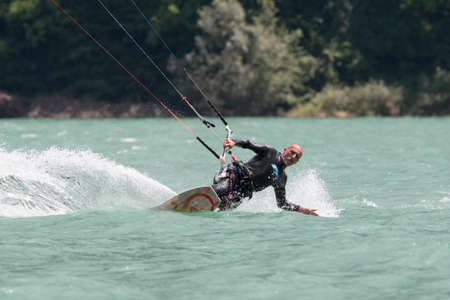 LAKE OF SANTA CROCE, ITALY - JULY 12: Professional kite-surfer demonstrating his ability 2014, July 12, 2014 in Lake of Santa Croce, Alpago, belluno, Italyのeditorial素材