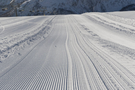 Fresh snow groomer tracks on a ski piste in the dolomites