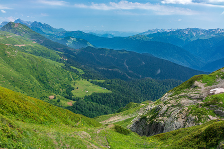 View over the Green Valley, surrounded by high mountains on a clear summer day. Krasnaya Polyana, Sochi, Russia.の写真素材