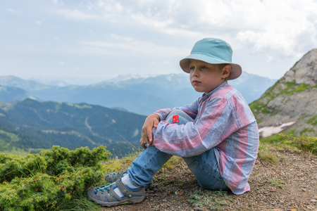 Boy-traveler in panama is resting on the top of the mountain. Caucasus, Russiaの写真素材