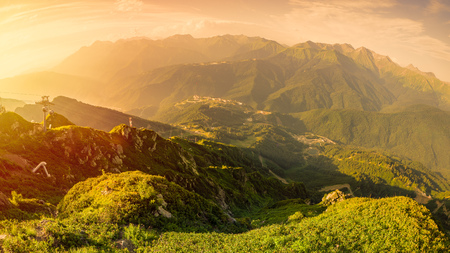 Panoramic view of the sunset in summer from the top of the Aibga range to the ski resort. Krasnaya Polyana, Sochi, Caucasus, Russia.の写真素材