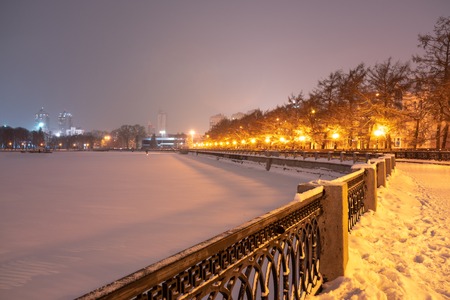 Embankment of the frozen city pond on a quiet winter night. Yekaterinburg, Russiaの写真素材