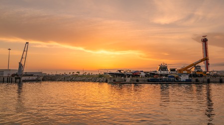 Boats in the port docks during orange sunsetの写真素材