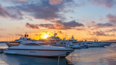 Beautiful orange sunset in the sea harbor with moored yachts. Sochi, Russia.