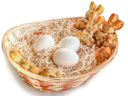 Eggs and homemade cookies in the shape of rabbits in a basket for Easter. Background with copy spaceの写真素材