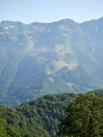 Mountain range with the green slopes on a clear summer day. Ski slope in summer. Mountains in the summer.の写真素材