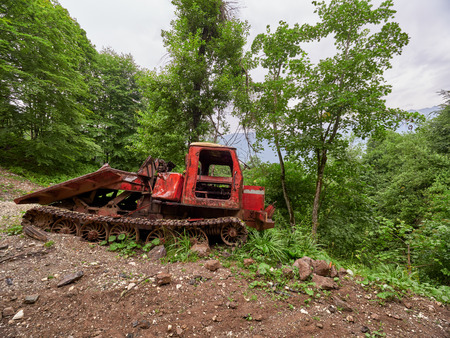 Abandoned snowcat on the ski slope in summer. Old equipment on a dirty road.の写真素材