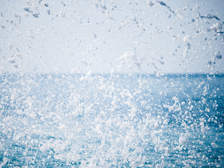 Splashes of water against the sea on a sunny summer day. Copy space backgroundの写真素材