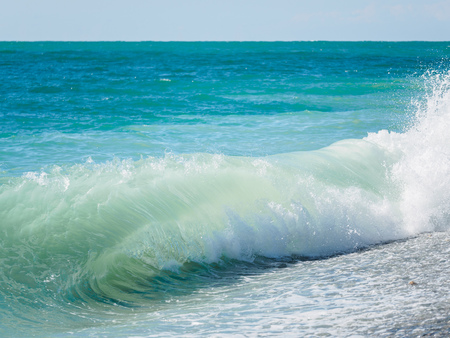 Blue sea and waves on a pebble beach. Seascape with waves and clear sky.の写真素材