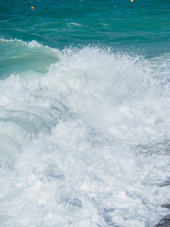 Splashes of water and foam against the sea on a sunny summer day. Copy space backgroundの写真素材