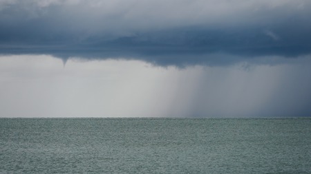 Seascape with rain in the distance. Thick clouds over the sea.の写真素材
