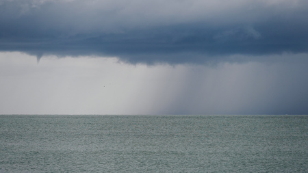 Seascape with rain in the distance. Thick clouds over the sea.の写真素材