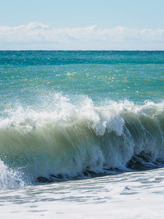 Blue sea and waves on a pebble beach. Seascape with waves and clear sky.の写真素材