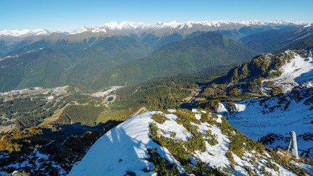 View of the snow-covered mountain range and the green valley in front of him. Krasnaya Polyana, Sochi, Caucasus, Russia.の写真素材