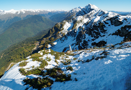 View of the snow-covered mountain range and the green valley in front of him. Krasnaya Polyana, Sochi, Caucasus, Russia.の写真素材