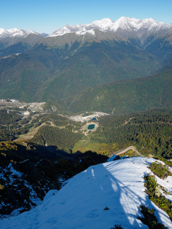 View of the snow-covered mountain range and the green valley in front of him. Krasnaya Polyana, Sochi, Caucasus, Russia.の写真素材