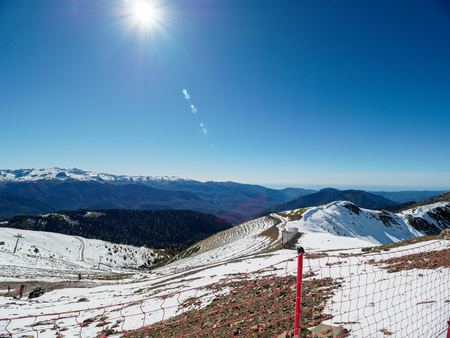 Snow slope of a high mountain with a cable lift. Blue sunny sky.の写真素材
