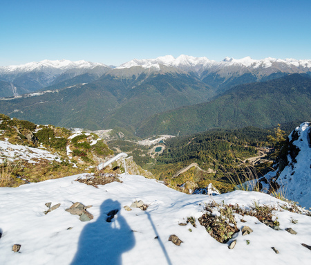 View from the snow-covered mountain range to the green valley in front of him. Krasnaya Polyana, Sochi, Caucasus, Russia.の写真素材