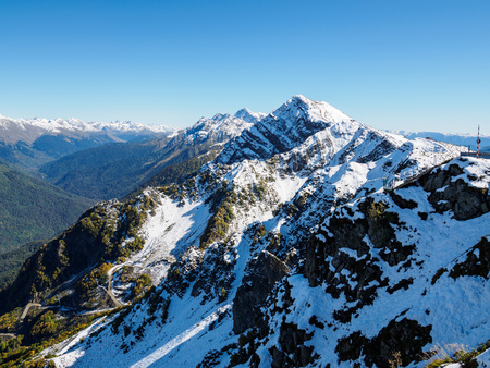 View of the snow-covered mountain range and the green valley in front of him. Krasnaya Polyana, Sochi, Caucasus, Russia.の写真素材