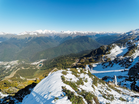 View from the snow-covered mountain range to the green valley in front of him. Krasnaya Polyana, Sochi, Caucasus, Russia.の写真素材