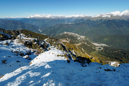 View from the snow-covered mountain range with cableway to the green valley in front of him. Krasnaya Polyana, Sochi, Caucasus, Russia.の写真素材