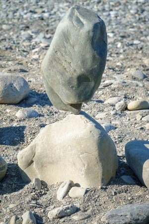 Balancing large stones in equilibrium. Meditation and relaxation on the beach.の写真素材